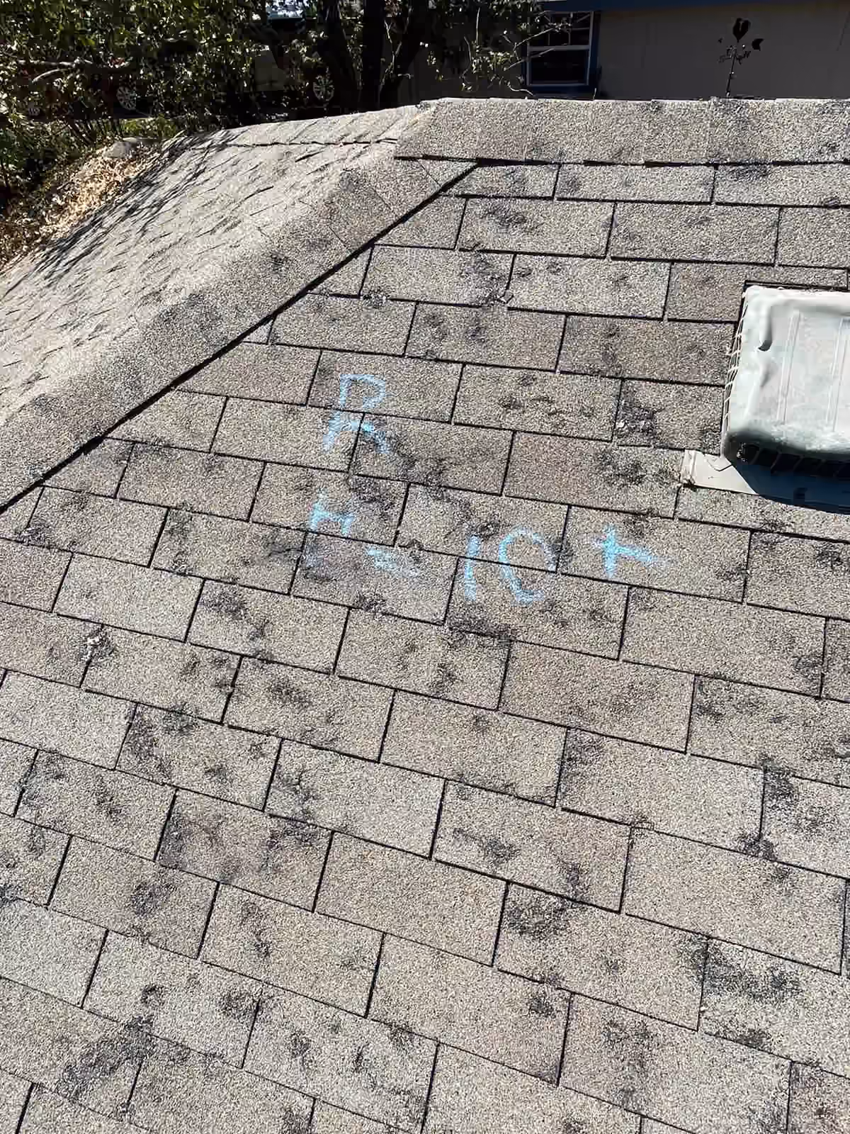 Shingle roof with visible surface marks and blue inspection notes