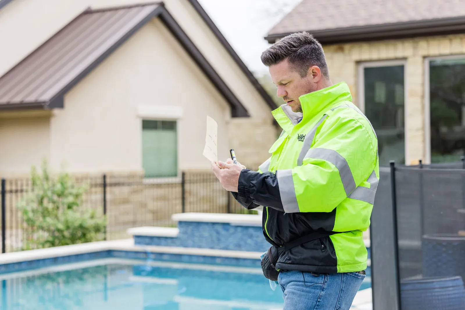 An Ark Roofer inspector recording measurements on site during an exterior inspection