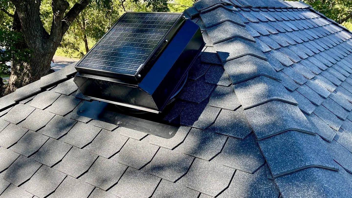 A solar attic fan mounted on a residential roof