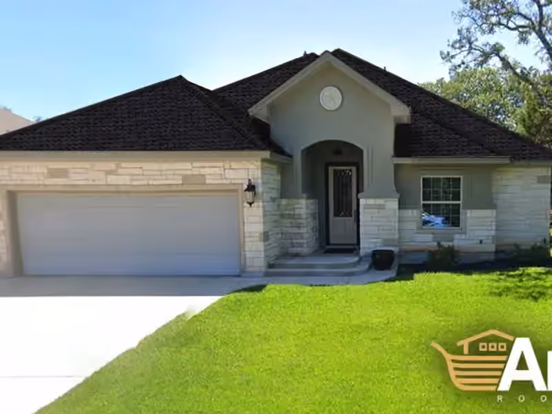 Dark shingle roof above light stone and trim on a home