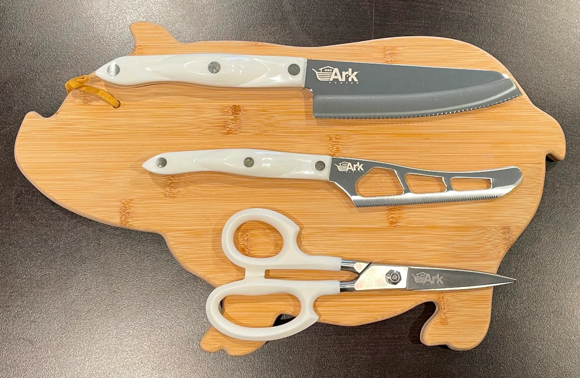 The Ark Roofer Cutco 3-piece set: a knife, cheese knife, and shears on a bamboo board