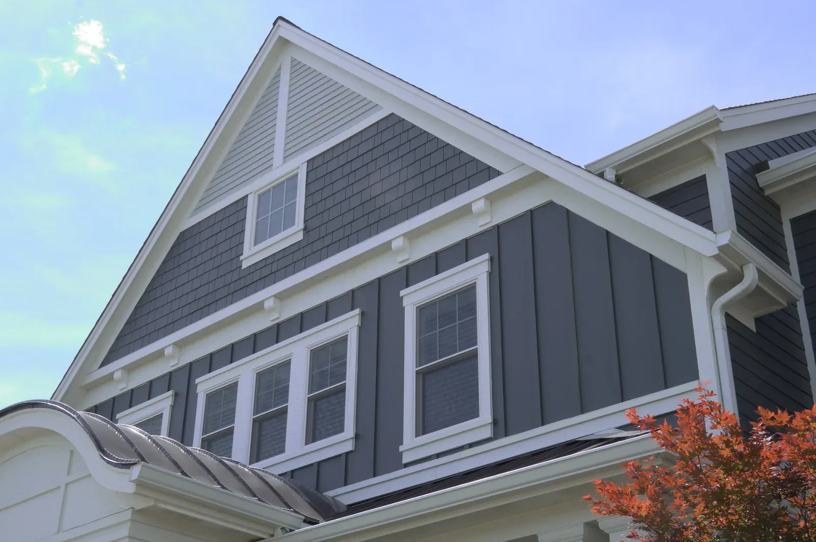 Board-and-batten and shake siding with white trim on a two-story home