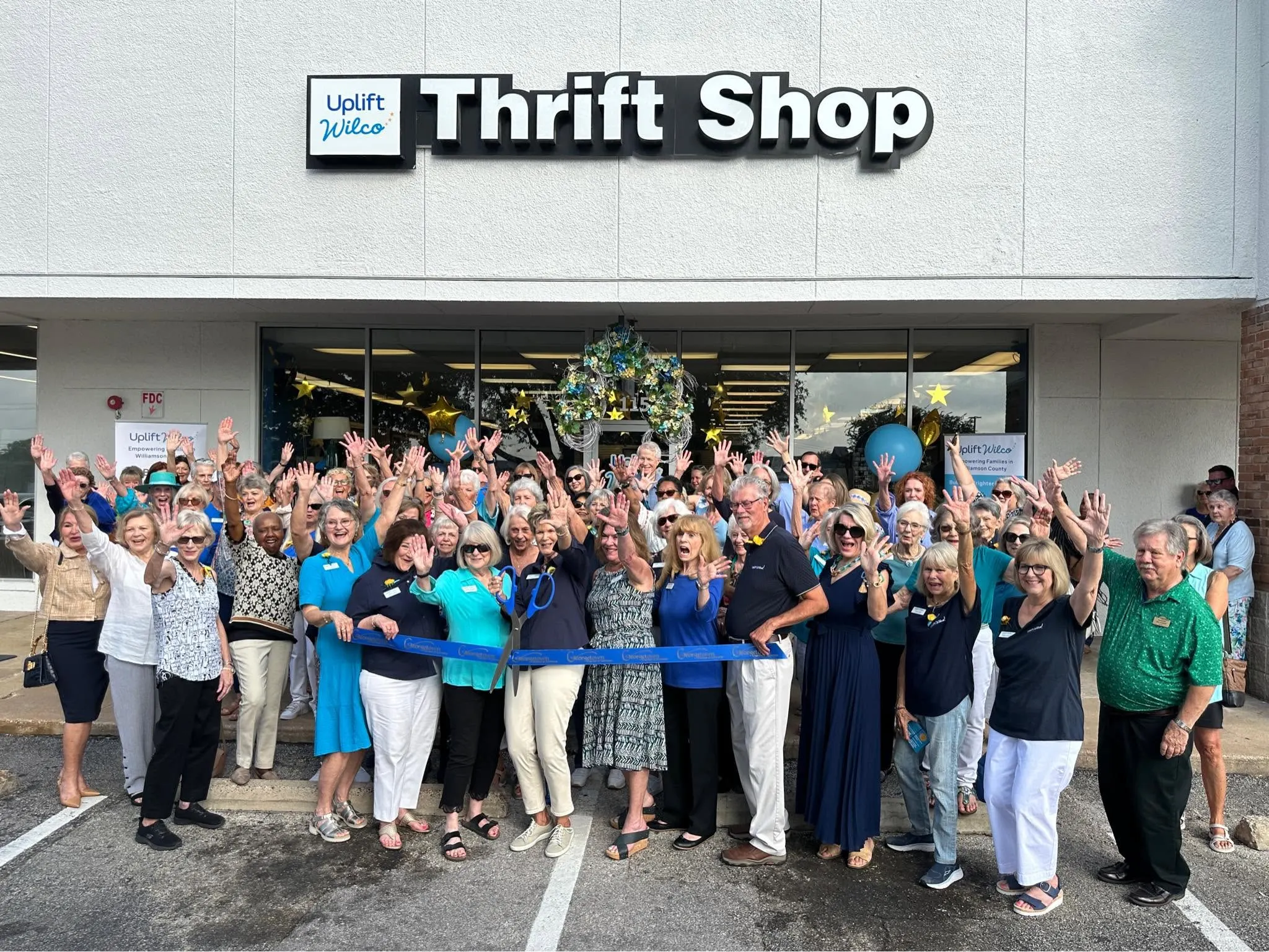 Uplift Wilco volunteers celebrating outside the Georgetown thrift shop