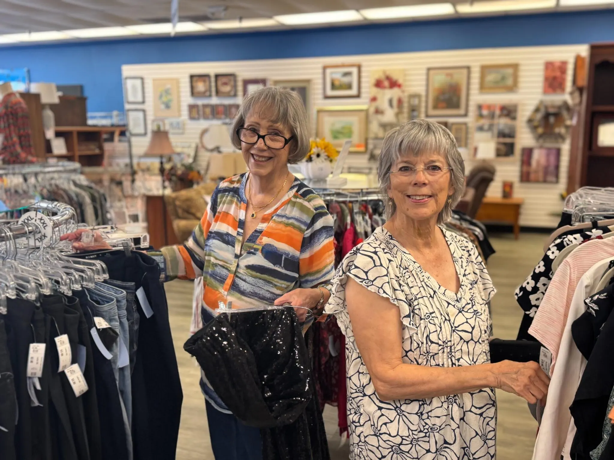 Two Uplift Wilco volunteers working among donated clothing