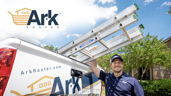 A smiling worker loads a ladder onto a service van, promoting a roofing company on a sunny day.