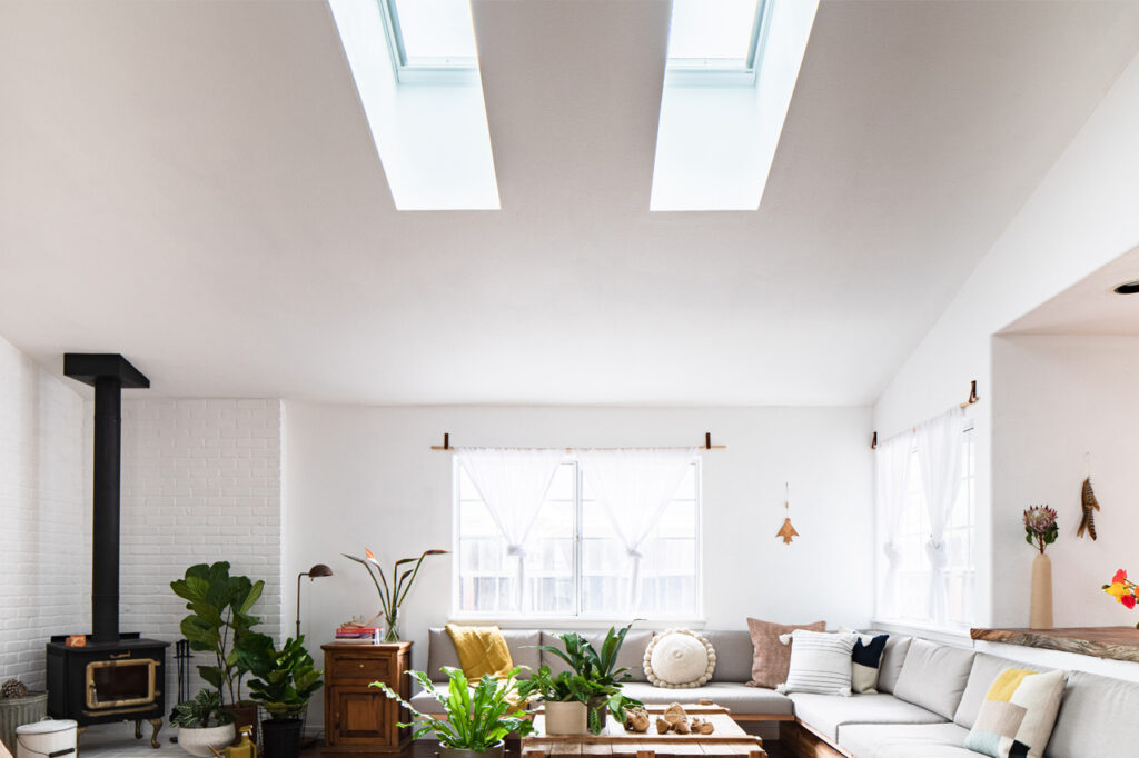 A living room with natural light coming through two skylights in the ceiling.