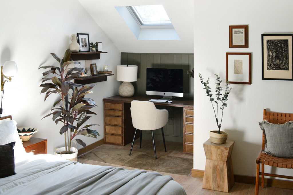 A bedroom with a white wall, a dark green accent wall, and a skylight.