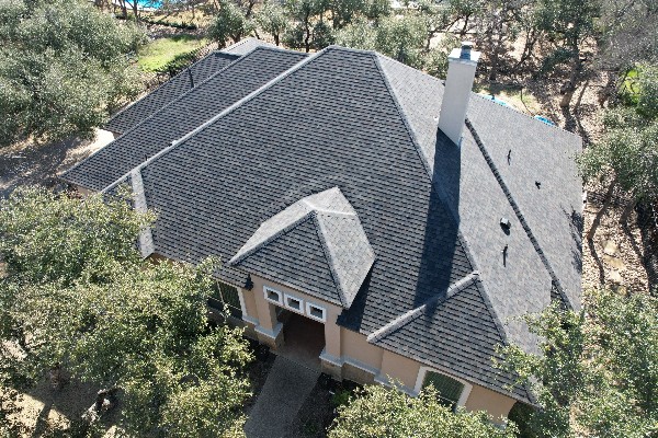 Aerial view of a house with a dark shingle roof