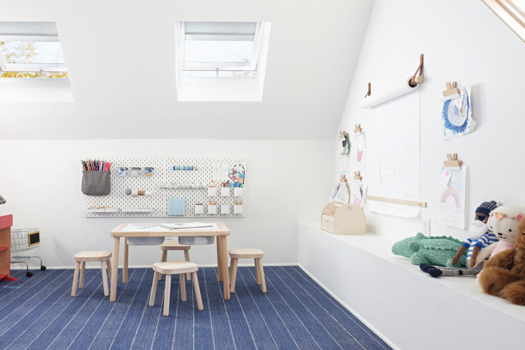 Children's playroom with skylights and art supplies on the walls.