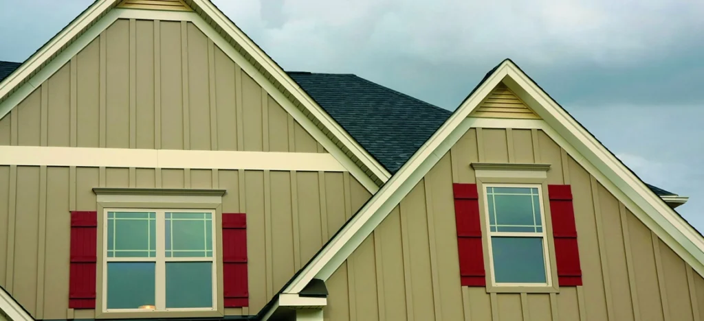 Roofer holding a laptop while discussing a roofing project.