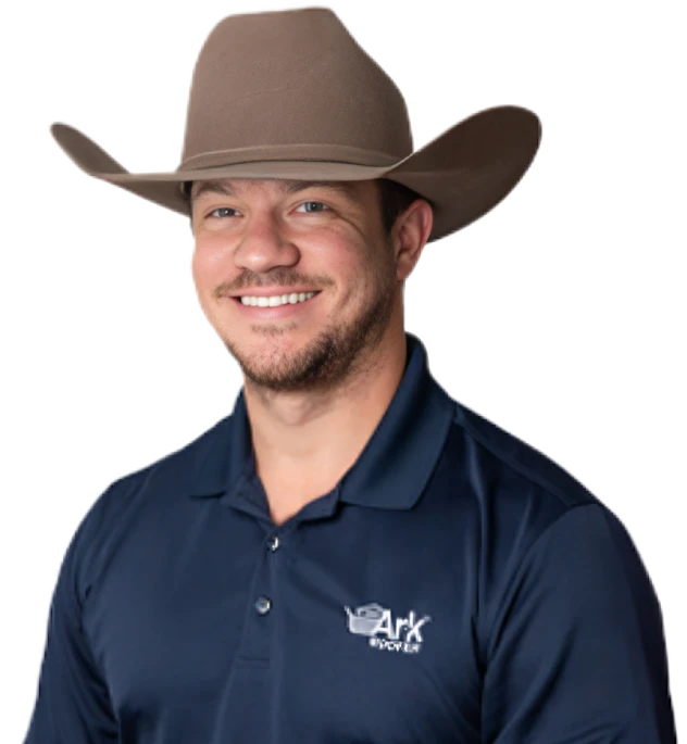 Smiling man in a cowboy hat wearing a navy blue polo shirt with the 'Ark Roofer' logo