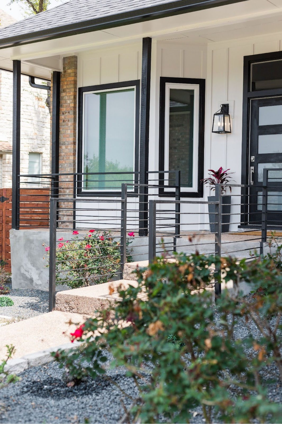 Close-up of a porch with black railings and vibrant flowers.