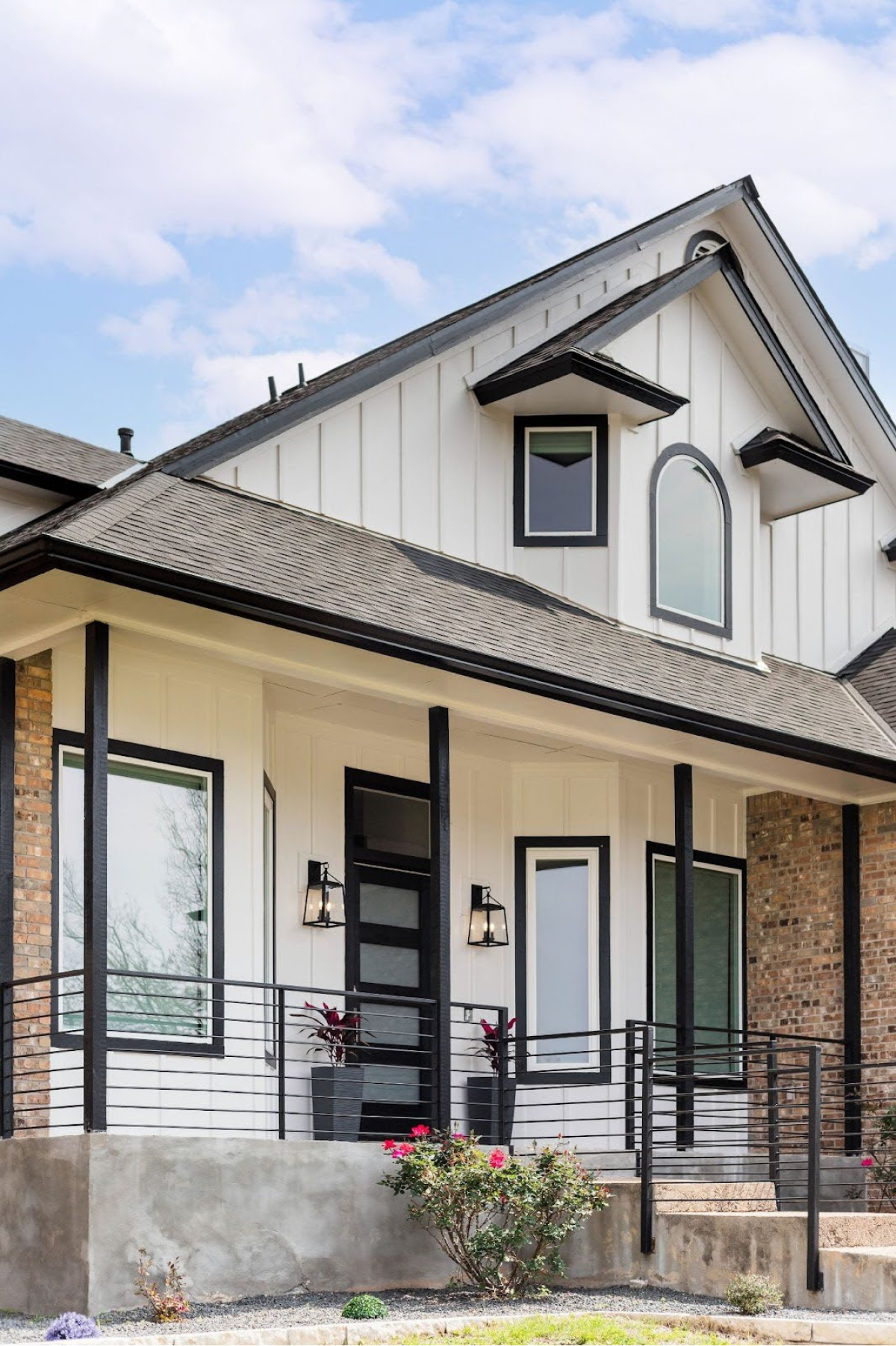 Stylish white and brick house with a black garage door