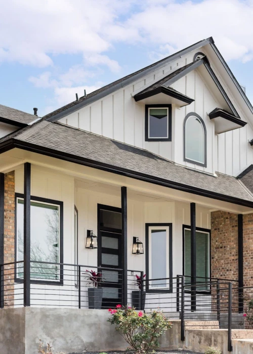 Stylish white and brick house with a black garage door