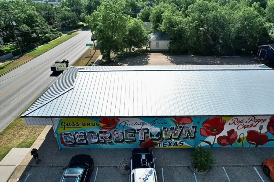 A top view of a building in Georgetown, Texas, featuring a clean metal roof and mural on the side.