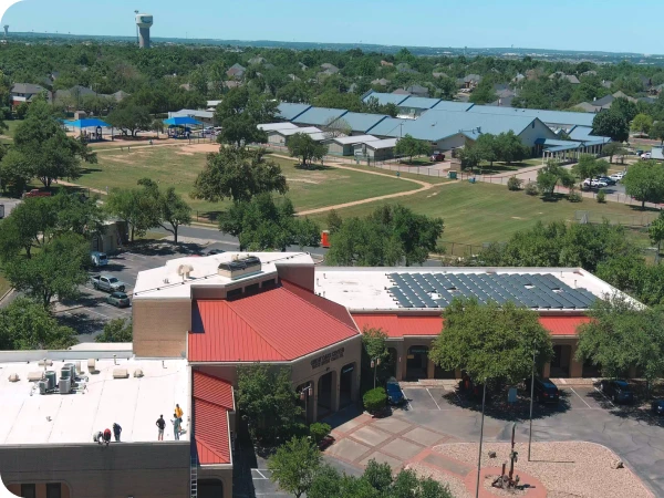 An aerial view of a commercial building with solar panels installed on the rooftop.