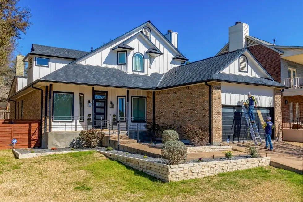 Home exterior with new siding installation, featuring a modern design with brick and wood panels.