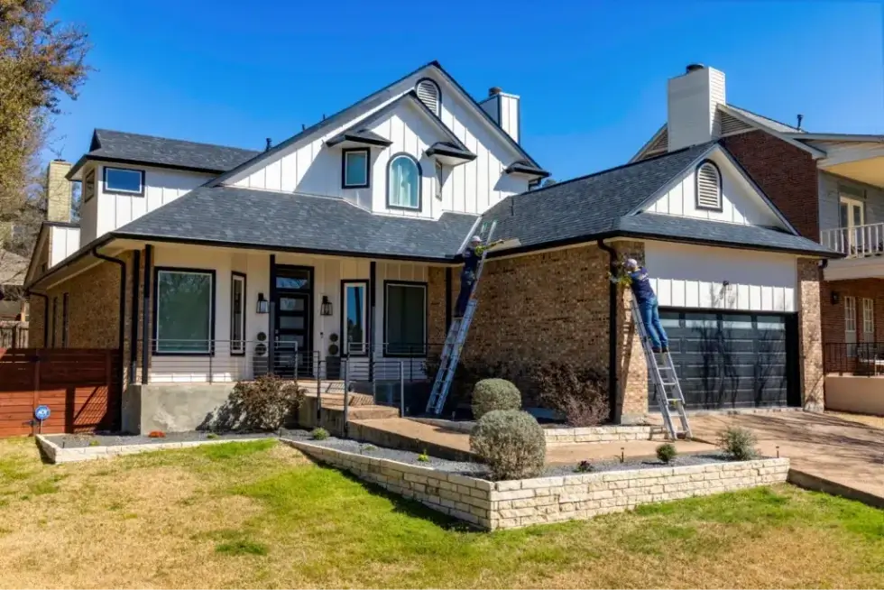 Professional gutter installation on a modern residential home with brick and siding.