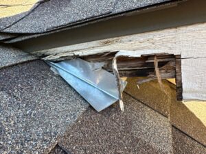 Rotted fascia board with exposed flashing damage.